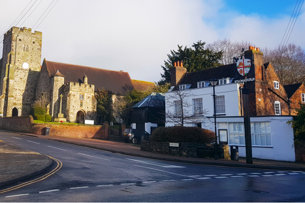 A street with a church and white building