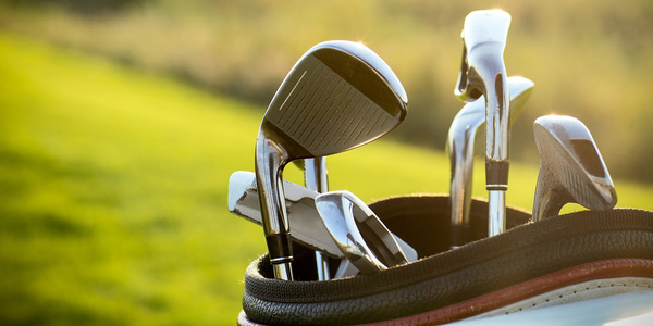 golf-clubs-drivers-over-green-field-background