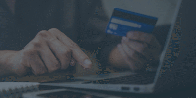 a dark image of someone with a card and on a laptop to help visualise the deadline for paying tax underpayments through PAYE 30 december